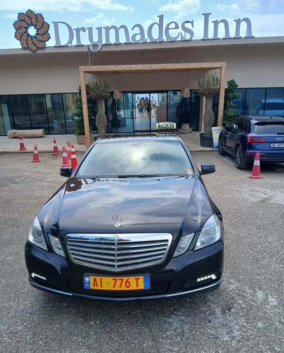 Taksi Dhërmi Joni, Mercedes E-Class i zi para hotelit Drymades Inn